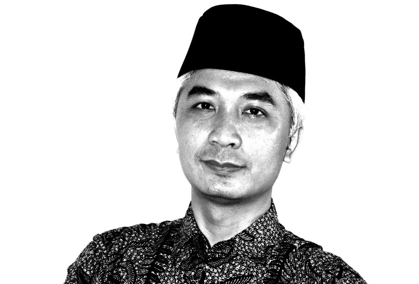 A man wearing peci hat and batik shirt in black and white photo